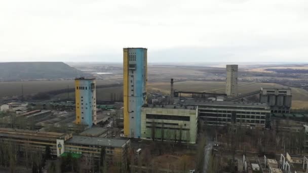 Παλιό ασανσέρ ανθρακωρυχείου και σκωρίες σε μια συννεφιασμένη μέρα. Εκλεπτυσμένη κατασκευή φρεατίων εξόρυξης άνθρακα, εργοστάσιο και κατασκευές. Ορυκτά καύσιμα και ορυκτά ορυχεία βαρύ βιομηχανικό τοπίο με terrikons. — Αρχείο Βίντεο