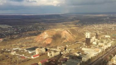 Bulutlu bir günde kömür madeni asansörü ve kömür yığınları. Eski kömür madenleri, yıpranmış fabrikalar ve inşaatlar. Fosil yakıt ve mineraller bölgelerle ağır sanayi arazileri kazıyor..