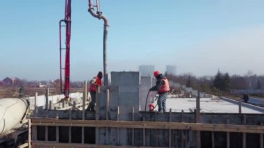 Ukrayna, Mariupol - 1 Eylül 2020. Beton patlayıcı vinç kol kamyonu havadan geliyor. Formalitelere bina karışımı dökülüyor. İnşaat işçileri tribün sahnesinden beton duvarlar döker..