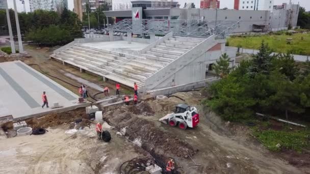 Ucrania, Mariupol - 1 de septiembre de 2020. Aérea de electricistas colocando cables de alimentación subterráneos en tubos corrugados flexibles de doble capa. Trabajadores enrutando cables eléctricos a través de tuberías en trinchera. — Vídeos de Stock