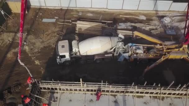 Ukraine, Mariupol - 1er septembre 2020. Aerial of concrete boom pump grue arm truck with outriggers couling building mixture into a formwork. Les travailleurs de la construction versent des murs en béton de tribune. — Video