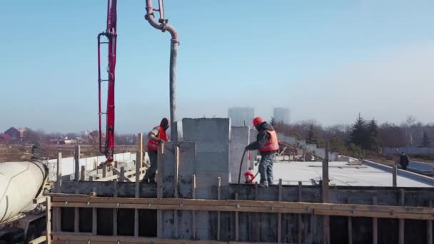 Ucrania, Mariupol - 1 de septiembre de 2020. Aérea de la bomba de brazo de la bomba de hormigón camión de brazo con outriggers verter la mezcla de construcción en un encofrado. Trabajadores de la construcción vierten muros de hormigón de tribuna. — Vídeos de Stock