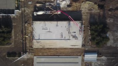 Beton patlayıcı vinç kol kamyonu havadan geliyor. Formalitelere bina karışımı dökülüyor. İnşaat işçileri tribün sahnesinden beton duvarlar dökerler. Yukarıdan görüntüle.