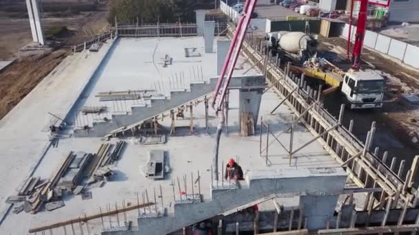 Ucraina, Mariupol - 1 septembrie 2020. Aerial de pompă de boom de beton macara braț camion cu declanșatoare turnarea amestecului de construcție într-un cofraj. Lucrătorii în construcții toarnă pereți de beton din etapa tribună. — Videoclip de stoc