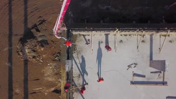 Ukraine, Mariupol - 1. September 2020. Antenne eines Betonauslegerpumpenkranwagens mit Stützen, die das Baugemisch in eine Schalung gießen. Bauarbeiter gießen Betonwände der Tribünenbühne. — Stockvideo