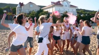 Neşeli gençler renkli tozlar sıçratıp Holi festivalini yavaş çekimde kutluyor. Arkadaşlar bahar festivalinde kuru boyayla oynarlar, renkler, aşk. Covid salgın izolasyonunun sonu.