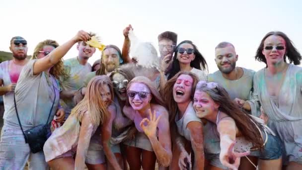 Joyful people smeared in colorful powder pose for photo at Holi festival. Friends take selfie, smile, laugh, play with gugal colors. Hindu holiday party. End of lockdown, covid pandemic, restrictions — Stock Video