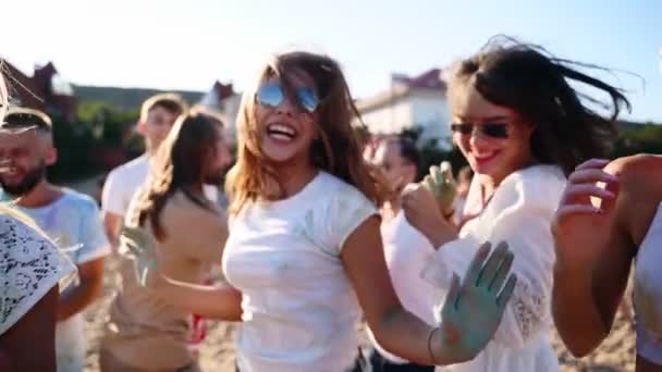 Springfreudige Menschen, die in buntes Pulver gehüllt sind, feiern das Holi-Fest. Freunde tanzen, haben Spaß beim Hindu-Urlaub am Strand in Zeitlupe. Ende der Pandemie-Isolation, Quarantäne, Beschränkungen. — Stockvideo