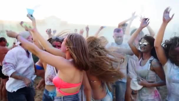 Skákání a tanec mladí lidé se baví a házet suché barvy do vzduchu na festivalu Holi ve zpomaleném filmu. Přátelé slaví hinduistický svátek a konec uzamčení, covid pandemie, karanténa. — Stock video