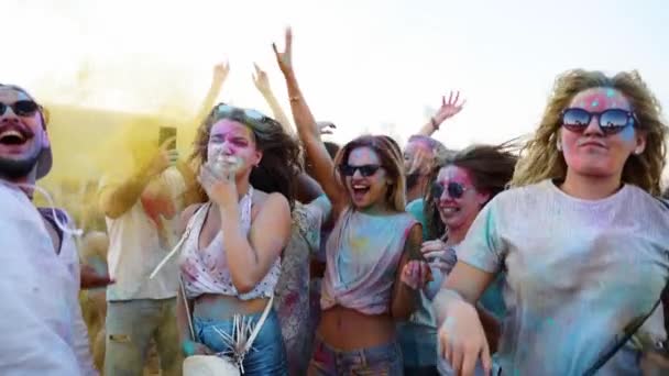 Χαρούμενοι άνθρωποι πασαλειμμένοι με πολύχρωμη σκόνη διασκεδάζουν, βγάζουν selfie, παίζουν με στεγνά χρώματα για να γιορτάσουν το Holi festival. Εξωτερικό πάρτι Ινδουιστών. Τέλος αποκλεισμού, έξαρση πανδημίας, περιορισμοί. — Αρχείο Βίντεο