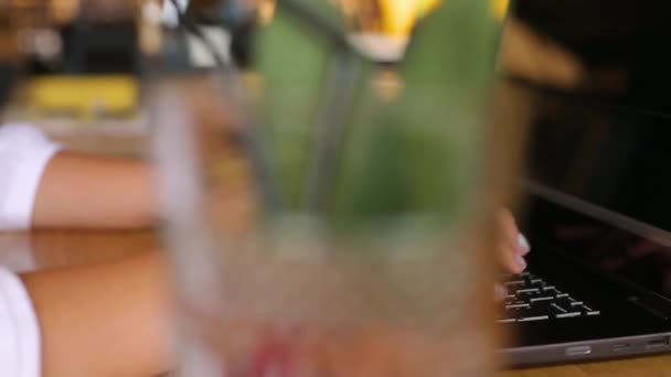 Camera alunecă în jurul mâinilor freelancerilor de sex feminin tastând pe tastatura laptopului în cafenea. O femeie de afaceri care lucrează la birou cu internet. Femeia caută un nou loc de muncă pe internet la coffeeshop. Slow motion. — Videoclip de stoc