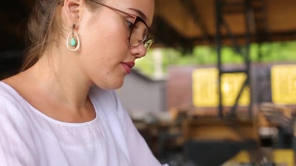 Camera glijdt rond vrouwelijke freelancers handen typen op laptop toetsenbord en stijgt in haar gezicht. Gemengde race zakenvrouw werkt op kantoor. Multi-etnische vrouw zoekt nieuwe baan op internet in cafe. — Stockvideo