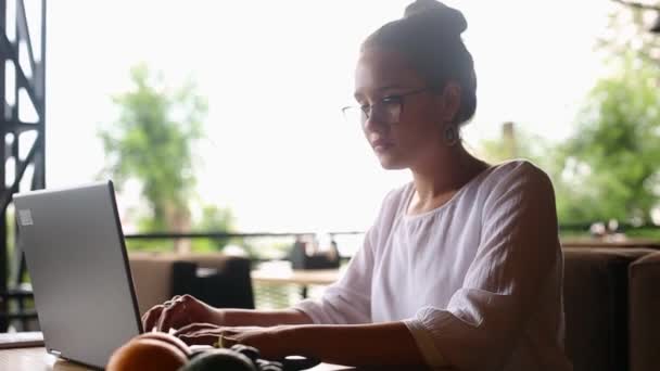 Kamera ślizga się wokół kobiet freelancerów wpisując na klawiaturze laptopa w zwolnionym tempie. Mieszana bizneswoman rasy pracująca w biurze. Multiethnic kobieta poszukuje nowej pracy w Internecie w kawiarni. — Wideo stockowe