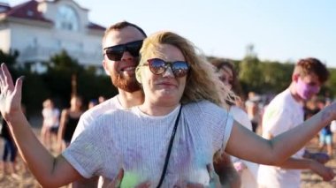 Gülen adam Holi Festivali 'nde yavaş çekimde güzel kadınların göğüslerini sallıyor. Çiftler Hindistan 'da bahar tatilinde eğleniyor, renkler, aşk. Covid salgınının sonu, karantina, kısıtlamalar.