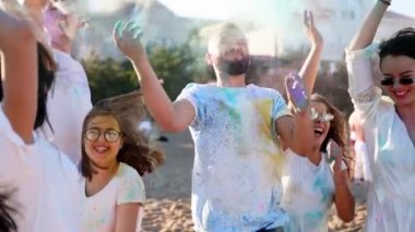 Neşeli insanlar, Holi festivalini yavaş çekimde kutlayan renkli tozlarla eğlenir. Arkadaşlar dans eder, Hindu bahar festivaline atlar, renkler, aşk. Covid salgın izolasyonunun sonu.
