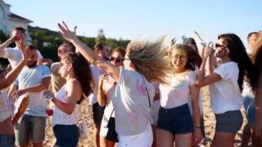 Neşeli insanlar renkli tozlarla lekelenmiş Holi festivalini kutluyor. Arkadaşlar Hindistan 'da bahar tatilinde eğlenirler, renkler, aşk. Erkekler dans eder, yavaş çekimde kumsala atlarlar. Covid salgın izolasyonunun sonu.