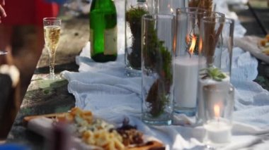Yemek masasından mum, bez, çiçek, sofra takımı, yemek takımı, yemek takımı, kap kacak ve içeceklerle süslenmiş peynir alır. Düğün partisi ziyafeti. Ormanda yemek servisi..