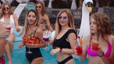 İnsanlar lüks otellerde kokteyl eşliğinde havuz partisi veriyorlar. Mayolu arkadaşlar kadeh tokuşturur ve bardakları içkiyle tokuşturur. Bikinili seksi kızlar suda rahatlar. Yavaş çekim