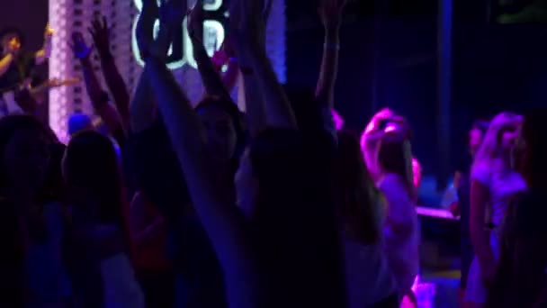 Mariupol, Ukraine - 25 July 2021. People dancing and cheering in Barbaris night club. Music band with singer, guitarist, drummer performs on stage. Silhouettes of men and women partying on dance floor — Stock Video