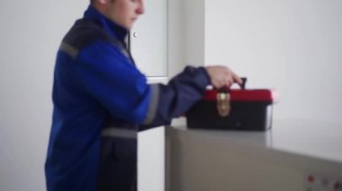 Elektrikçi alet kutusunu açar, elektrik ve sigorta kutusunu tamir etmek için tornavida alır. Üniformalı usta ofisteki ışığı tamir etmek için elektrik panelini söküyor. Tamirci ev içi sorunları düzeltiyor.