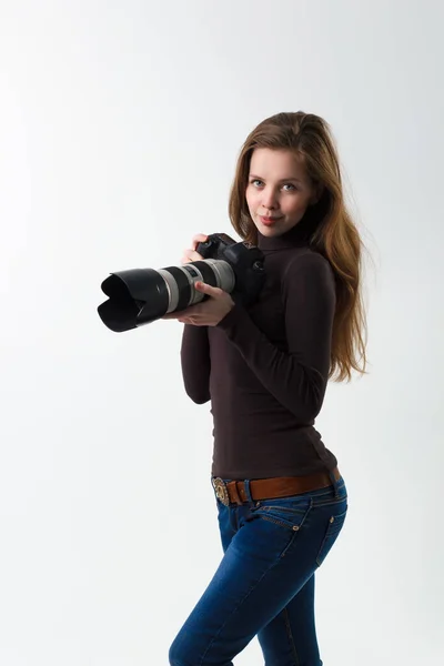 Piękna fotograf dziewczyna z profesjonalnym aparatem dslr pozowanie na białym tle w studio. Photo learning, nauka, koncepcja szkolenia — Zdjęcie stockowe