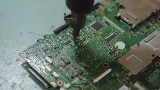 Elektronische Reparatur-Servicemitarbeiter löten Elektronikbauteile mit einer Heißluftpistole. Techniker wärmt Mikrochip auf, um Computermotherboard zu reparieren. — Stockvideo