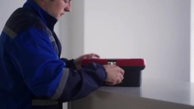 Elektrikçi alet kutusunu açar, elektrik ve sigorta kutusunu tamir etmek için tornavida alır. Üniformalı usta ofisteki ışığı tamir etmek için elektrik panelini söküyor. Tamirci ev içi sorunları düzeltiyor.