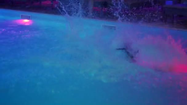 Mariupol, Ukraine - July 24, 2021. Cheerful women jumping to water on night pool party. Female friends in swimwear have fun in private holiday villa. Hot girls dive into the water. — Vídeo de Stock