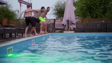 Lüks otellerde yüzme havuzunda zıplayan mutlu arkadaşlar. Mayolu gençler özel tatil köşkünde gece partisi veriyorlar. Suya dalan adamlar. Yavaş çekim.
