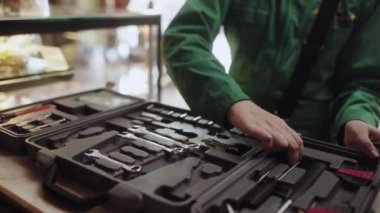 Kahve makinesini tamir ediyor ve işaret veriyor. Kadın kahve makinesini tamir etmek için aletler kullanıyor. Hızlı servis konsepti.