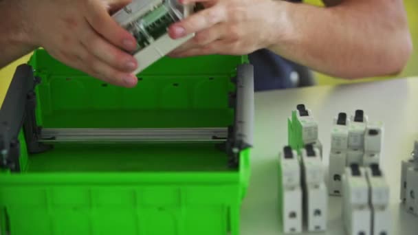 Elektriker montiert Sicherungskasten in Werkstatt Arbeiter installiert Energiezähler, Schalter und Leistungsschalter in Verteilerkasten auf dem Tisch. — Stockvideo