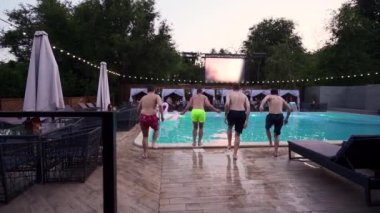 Lüks otellerde yüzme havuzunda zıplayan mutlu arkadaşlar. Mayolu gençler özel tatil köşkünde gece partisi veriyorlar. Suya dalan adamlar. Yavaş çekim.