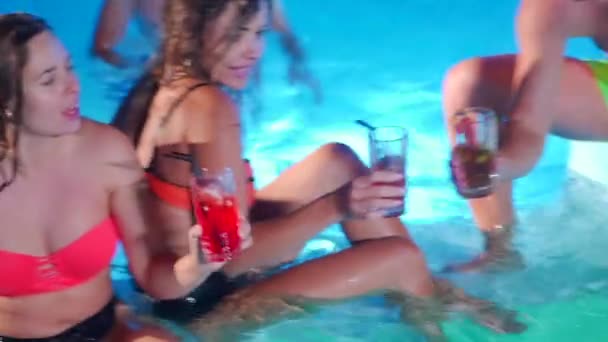 Skupina přátel připíjela, cinkala sklenicemi s koktejly na párty u bazénu. Veselí lidé v plavkách popíjejí nápoje, tančí, klubují a paří v luxusních rekreačních vilách. Zpomalený pohyb. — Stock video