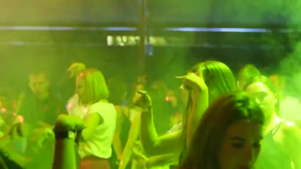 Mariupol, Ukraina - 15 czerwca 2019 r. Ludzie tańczą w nocnym klubie Barbarzyńców oświetlonym światłami. Sylwetki mężczyzn i kobiet imprezujących na parkiecie w zwolnionym tempie. — Wideo stockowe