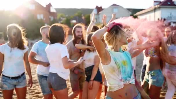 Pretty girl with tattoo smears hair with colored powder, shouts, turns head left and right, has fun at Holi festival. Woman shows freedom, end of covid restrictions and lockdown. Slow motion — Stockvideo