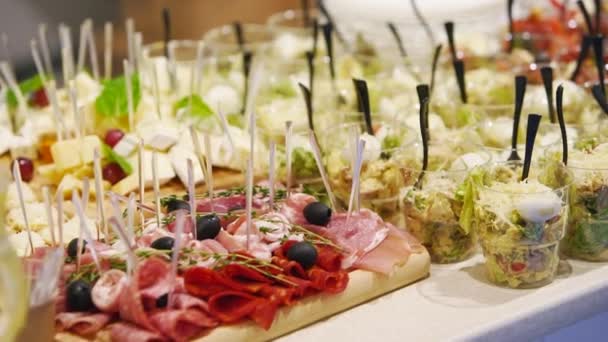 Catering υπηρεσία στο τραπέζι δεξιώσεων με canape σνακ στο εστιατόριο ή το ξενοδοχείο. Διακοσμημένο σετ φαγητού στα γενέθλια, τη γαμήλια γιορτή ή τον επαγγελματικό χώρο εκδηλώσεων. — Αρχείο Βίντεο