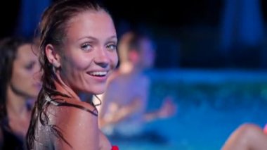 Çekici bir kadın, gece havuz partisinde öpüşme flörtü ve bikinisiyle takılıyor. Lüks bir özel villada havuzda eğlenen çekici bir kadın. Oyuncak kadın yavaş çekimde göz kırpar.