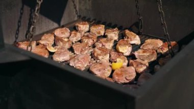 Yemek servisi için açık havada büyük bir endüstriyel fırında et kızartıyoruz. Aşçı kızarmış domuza baharat ve bitkiler döker..