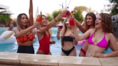 Bikinili kızlar havuzda kokteyl ve havuz partisi yaparlar. Lüks otellerde bardakları içkiyle dolduran kadınlar. Kırmızı mayo giymiş, dans eden, sudaki kulüplerde takılan kızlar. Yavaş çekim.