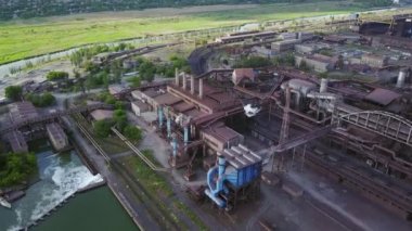 Aerial of industrial city with air atmosphere and river water pollution from metallurgical plant and blast furnaces near sea. Dirty smoke, smog from pipes of steel factory. Ecological issues concept.