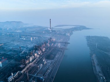 Metalurjik santralden kaynaklanan hava ve su kirliliği ve deniz limanı yakınlarındaki fırınlarla dolu bir sanayi şehri. Kirli duman, çelik fabrikasının borularından çıkan duman. Ekolojik konular kavramı.