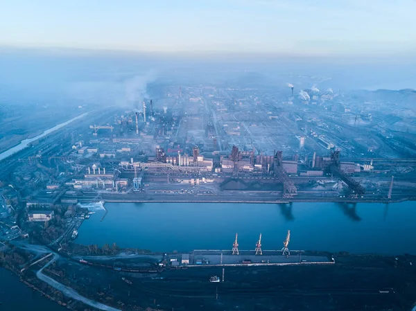 Metalurjik santralden kaynaklanan hava ve su kirliliği ve deniz limanı yakınlarındaki fırınlarla dolu bir sanayi şehri. Kirli duman, çelik fabrikasının borularından çıkan duman. Ekolojik konular kavramı.