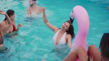 Arkadaşların özel bir yüzme havuzunda gece havuzu partisi var. Mayo giymiş mutlu gençler su sıçratıyor, şamandıralarla dans ediyor ve lüks bir tatil köyünde şişme yatak giyiyor..