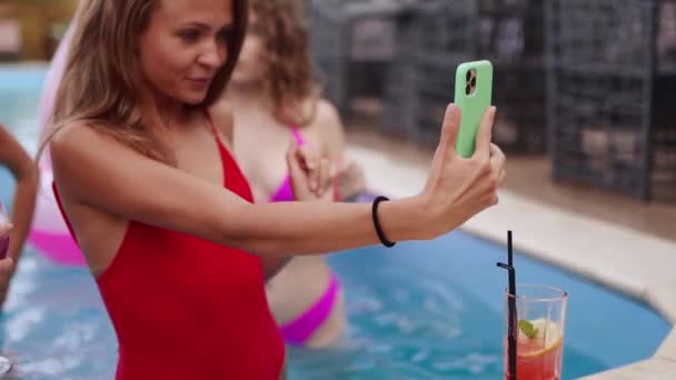 Reisebloggerin im Bikini macht Selfie-Foto mit Freunden bei Schwimmbadparty. Lifestyle-Vlogger filmt Vlog mit heißen Mädchen aus Luxus-Resorts. Weiblicher Livestream in sozialen Medien. — Stockvideo