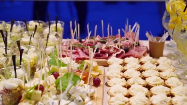 Catering service on banquet table with canape snacks in restaurant or hotel. Decorated food set on birthday, wedding celebration or business conference event venue. — Vídeo de stock