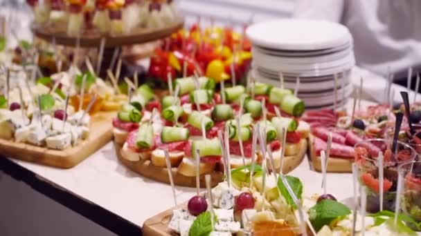 Catering service on banquet table with canape snacks in restaurant or hotel. Decorated food set on birthday, wedding celebration or business conference event venue. — Stock Video