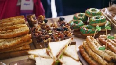 Catering service on a banquet table with burgers, puffs, donuts and sandwiches in restaurant or hotel. Decorated food set on birthday, wedding celebration or business conference event venue.