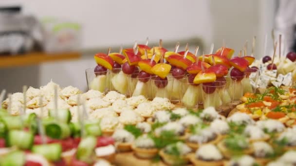 Catering υπηρεσία στο τραπέζι δεξιώσεων με canape σνακ στο εστιατόριο ή το ξενοδοχείο. Διακοσμημένο σετ φαγητού στα γενέθλια, τη γαμήλια γιορτή ή τον επαγγελματικό χώρο εκδηλώσεων. — Αρχείο Βίντεο