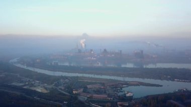 Aerial of industrial city with air atmosphere and river water pollution from metallurgical plant and blast furnaces near sea. Dirty smoke, smog from pipes of steel factory. Ecological issues concept.
