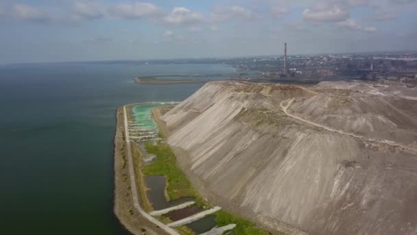 Aerial of metallurgical plants slag, scrap dump heap from metallurgical furnaces near sea of Azov. Slag heap from industrial production waste. Harmful production and air pollution. Ecological issues. — ストック動画